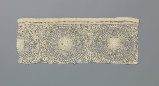 Strip of needle lace with suns surrounded by an ornamental border with angular curling lines forming small rectangles