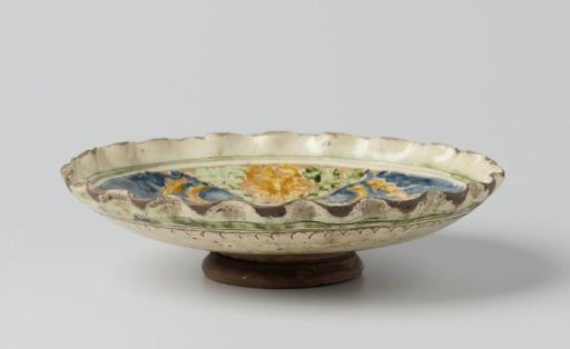 Dish, polychrome painted with a coat of arms within concentric circles and dolphins and leaves on the rim