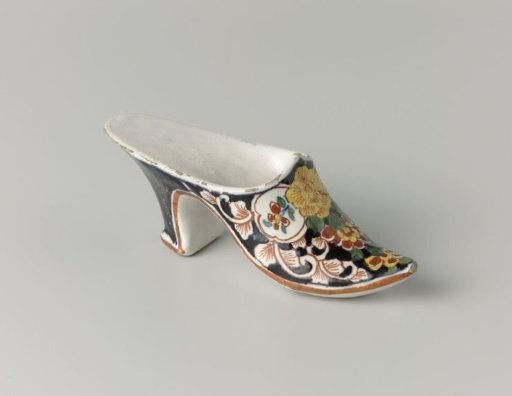 Faience slipper, polychrome painted with flowers on a black ground