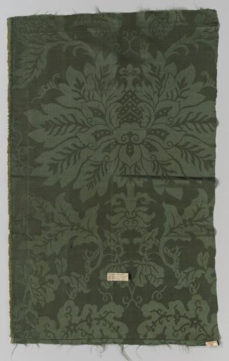 Fragment of light green silk damask with a pattern of flowers above leaves