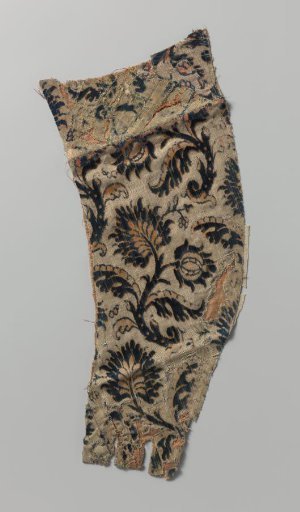 Fragment of silk velvet brocade with a pattern of curled branches with leaves and flowers in blue and pink on a light ground