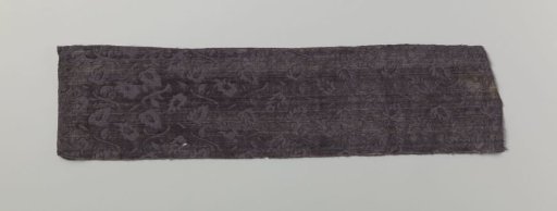 Fragment of purple silk velvet with a pattern of pruned flower branches