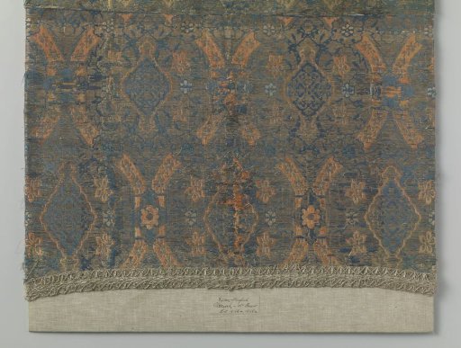 Fragment of silk lampas with a pattern including pomegranates, floral scrolls, and geometric motifs