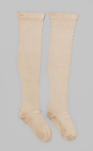 Stocking of plain cream-colored silk with a vertical line on the seam tapering into a palm motif