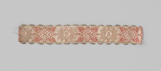 Ribbon of silk brocade; on a silver-colored ground a continuous pattern is applied of pink/orange squares and stars