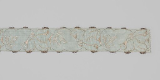 Ribbon of silver and blue silk brocade; on a light blue ground a running vine is worked in silver