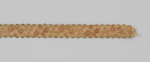 Ribbon of silk brocade, partly decorated with velvet; on a gold ground a pattern is applied of a continuous, wavy flower and leaf vine