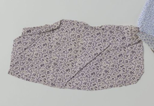 Fragment of printed cotton with floral scrolls and irregular spots in purple on a white ground