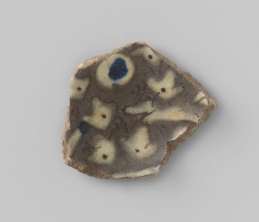 Fragment of soft grey-white earthenware with glaze over a black translucent underdrawing