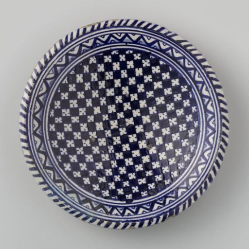 Plate decorated with a blue-and-white checkered pattern surrounded by concentric circles containing a zigzag motif