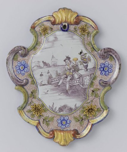 Plate, cartouche-shaped, painted in many colours with a man blowing a horn