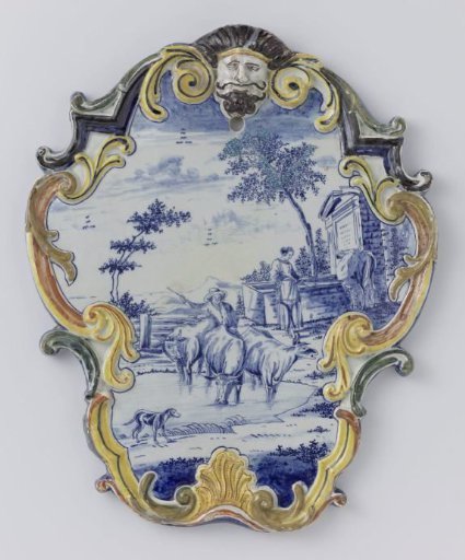 Plate in the shape of a cartouche with a mask; painted in blue with a landscape with cows