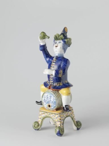 Lid of decorative object: man with bottle in hand, on a barrel
