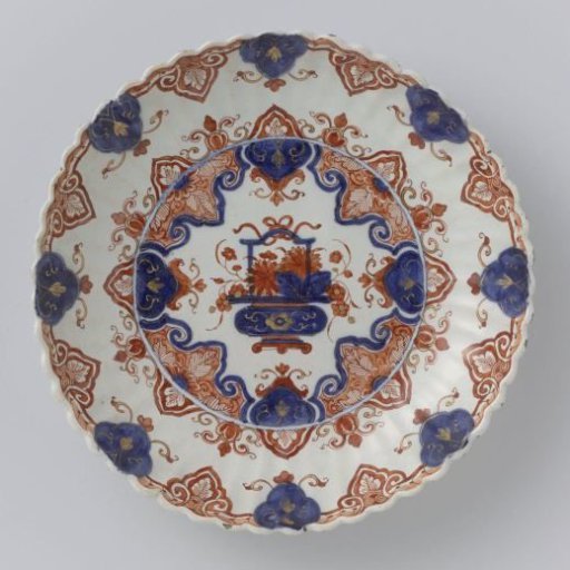 Dish, decorated with a flower basket within a lace border
