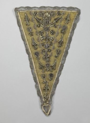 Stomacher or triangular breastpiece of silver brocade between yellow silk ribbons covered with silver tulle passement, both decorated with ornaments of (originally gilded) leaf silver over parchment and edged with a scalloped border of silver tulle, silk appliques, silk chenille, bow