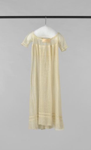 Children's dress with short sleeve, high waist and back fastening with thin drawstring, executed in cream openwork knitting.