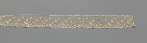 Edge of needle lace with a row of leafy sprigs and a lower border of linked medallions from which leafy sprigs emerge