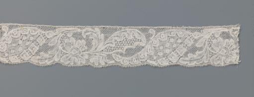 Strip of bobbin lace with a flower surrounded by leaves and a composite leaf-shaped motif