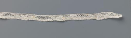 Strip of bobbin lace with a trapezoidal cartouche and a four-leaf clover