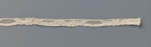 Strip of bobbin lace with trapezium-shaped cartouche and four-leaf clover