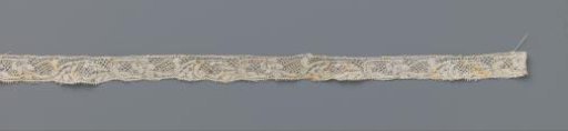 Strip of bobbin lace with a leaf forming a rectangle and a flower on a curved stem