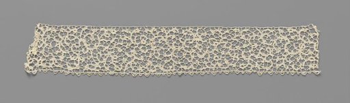 Strip of needle lace with fine strongly curved vines