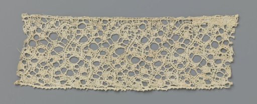Strip of bobbin lace with a tangle of oval knobs