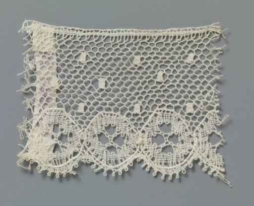 Strip of bobbin lace with linked circles along the underside