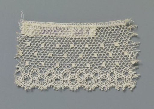 Strip of bobbin lace with a narrow ornamental band along the underside of linked small circles
