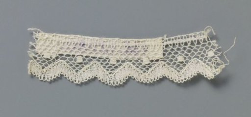 Strip of bobbin lace with a row of square motifs and a zigzag line along the bottom
