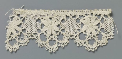 Strip of bobbin lace with flower with eight petals in three-lobed shell