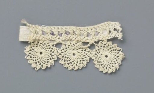 Strip of knotted lace with three small circles under a narrow straight band