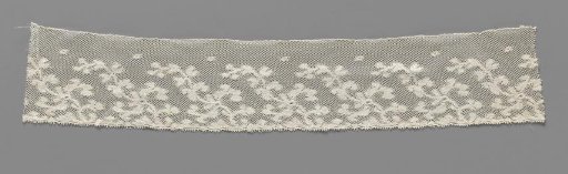 Strip of machine-made lace with stylized flowers on obliquely directed branches