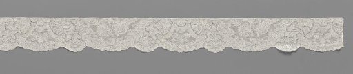 Strip of bobbin lace with semi-circular field and trapezium-shaped cartouche