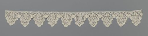 Border of bobbin lace with a flower in triangular scallops with lobes