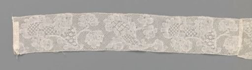 Strip of bobbin lace consisting of two pieces with different patterns