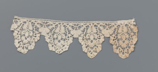 Border of bobbin lace with fan flower in trapezoidal vase