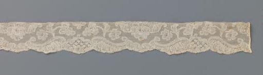 Strip of lace with a three-lobed cartouche and hanging flower with a drop-shaped heart