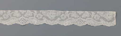 Strip of lace with a three-lobed cartouche and hanging flower with a drop-shaped heart