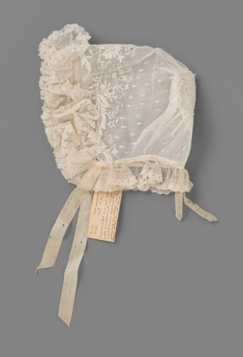 Children's cap of white net fabric decorated with white work and needle lace, trimmed with a border of Brussels lace