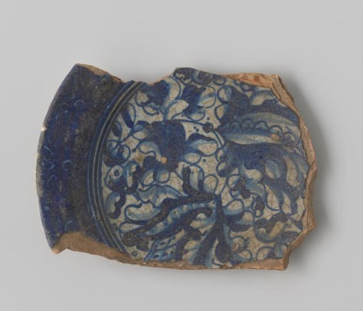 Fragment of a earthenware plate with blue decoration of leaves