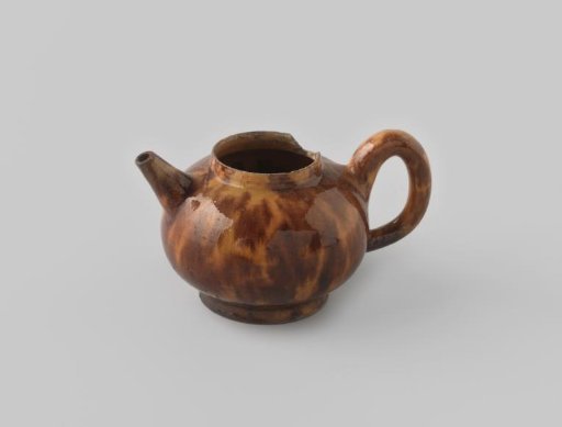 Teapot of red-baking earthenware, damaged, with swirled glaze in beige and brown on the exterior