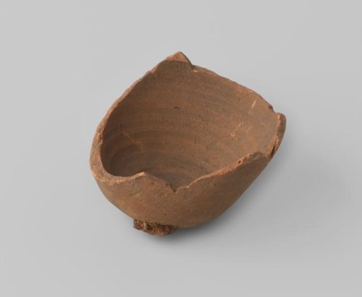Bell-shaped fragment of an unglazed object with a red-fired shard, with a lump of molten metal on the exterior.