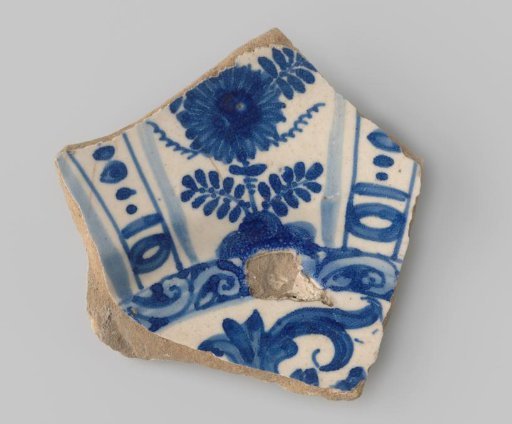 Sherd of whiteware, with a floral motif in light and dark blue on the front