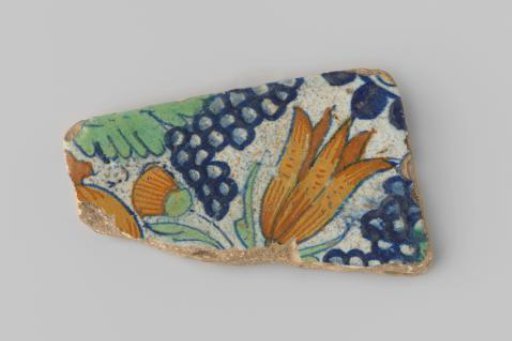 Fragment of a tile with yellow sherd, provided with a painting of flowers and fruits in yellow, green and blue on a white ground