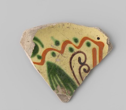 Fragment of a plate of white-firing earthenware, with yellow glaze on the front featuring decoration in orange, green, and brown