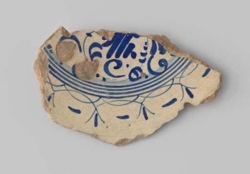 Fragment of white-firing earthenware with decoration of floral forms and circles in blue