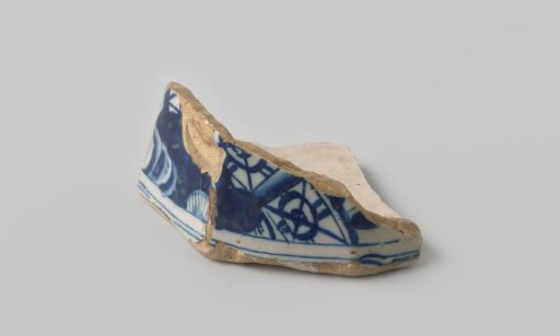 Fragment of white-firing earthenware, with a painting in blue on a white ground on the outside