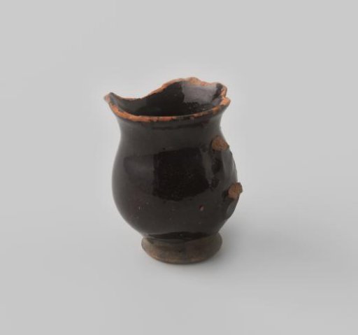 Jug, damaged, of red-firing earthenware with brown glaze on the inside and outside