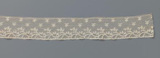 Strip of bobbin lace with tilted ovals under a scattering pattern of twigs